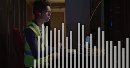Monitoring technician wearing vest and red muffs in data center, with laptop and cables, copy space....
