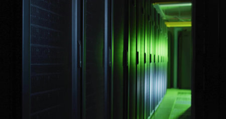 Glowing row of server racks lining data center corridor, with green LED lights and cable trays....