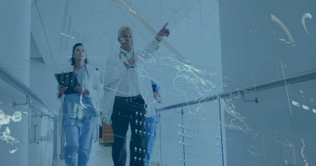 Walking doctor carrying tablet with team down hospital corridor, viewing holographic map overlay....