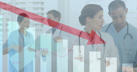 Reviewing medical team in scrubs and coats analyzing declining metrics in corridor, with bar charts. Healthcare, analytics, collaboration, modern, professionalism, data, innovationの写真素材