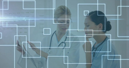 Studying medical chart and viewing digital overlays, doctors wearing scrubs, lab coat in clinic. Healthcare, technology, professionalism, innovation, accuracy, collaboration, diagnosticsの写真素材