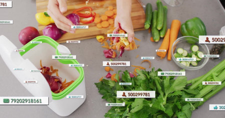 Gathering vegetable peels over compost bin on kitchen countertop, cutting board with sliced carrots. Sustainable, ecofriendly, culinary, minimalism, organic, healthy, preparationの写真素材