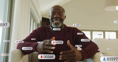 Gesturing man in burgundy sweater speaking from sofa in living room. Modern, casual, interior, technology, communication, lifestyle, animatedの写真素材