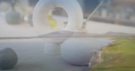 Blending white ceramic sculpture and spherical vase with coastal hills at tabletop double exposure....