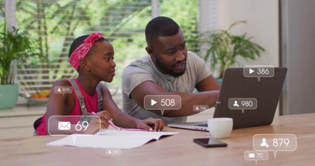 Pointing father and daughter studying near window at home, using laptop notebook pencil mug. Family, education, learning, mentorship, creative, home setting, growthの写真素材