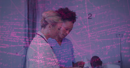 Doctor in white coat and nurse in blue scrubs reviewing tablet in hospital room, with bed. Medical, healthcare, digital, hospital, clinical, patient care, technologyの写真素材