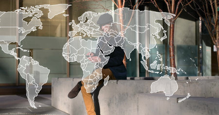Sitting adult male checking smartphone on bench in plaza, wearing dark coat. Urban, modern, reflective, tech, contemplative, nighttime, minimalistの写真素材