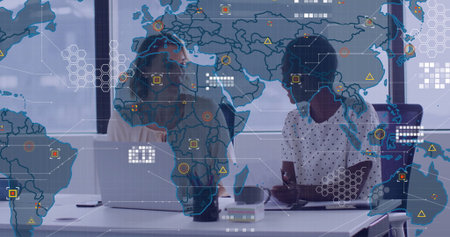Collaborating colleagues analyzing map overlay on laptop at conference room, smartphone coffee mug. Professional, teamwork, modern, analytics, digital, strategy, urbanの写真素材