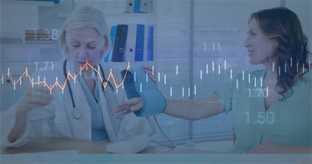Senior female doctor checking patient blood pressure with cuff on clinic desk, stethoscope, binders....