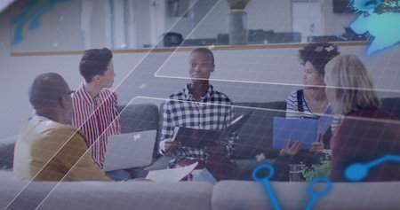 Woman holding folder and typing on laptop in office lounge with holographic graphics and table. Collaboration, teamwork, digital, innovation, modern, workspace, professionalの写真素材