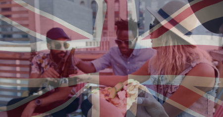 Friends sharing beer bottles and pizza slice on rooftop terrace bench with Union Jack overlay. Casual, friendship, urban, celebration, lifestyle, vibrant, outdoorの写真素材
