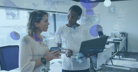 Mid-adult professionals wearing business attire analyzing charts in office with laptop, coffee mug. Business, workspace, technology, collaboration, innovation, modern, professionalの写真素材