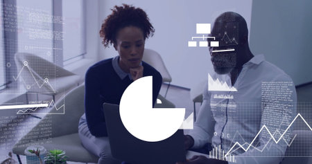 Analyzing two professionals reviewing laptop screen in office lounge with charts and coffee mug. Collaboration, teamwork, modernoffice, dataanalysis, financialmetrics, productivity, innovationの写真素材