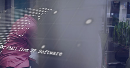 Leaning man in magenta shirt examining monitor showing code overlay in office, LED grid, copy space....
