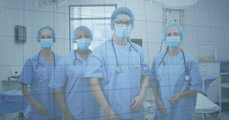 Standing surgical team wearing blue scrubs in operating room, with stethoscopes and surgical light. Medical, healthcare, surgical, hospital, teamwork, professionalism, sterileの写真素材
