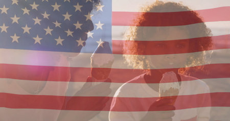 Mother and son holding chocolate-dipped ice cream cones in front of faint US flag overlay. Family, celebration, patriotism, outdoor, warmth, bonding, summerの写真素材
