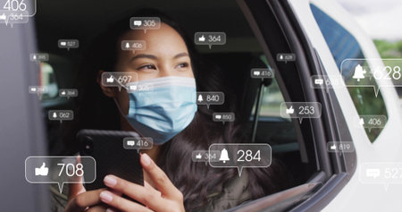 Holding smartphone masked passenger checking notification icons inside car near open window frame. Technology, communication, connectivity, urban, modern, lifestyle, relaxationの写真素材
