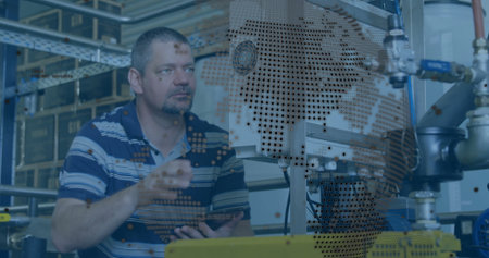 Standing male technician gesturing towards machinery in factory, with tablet and world map overlay....