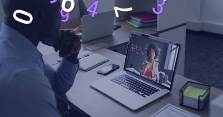 Sitting senior man wearing blue shirt participating in meeting using laptop in office, copy space. Professional, collaboration, technology, business, communication, modern, workspaceの写真素材