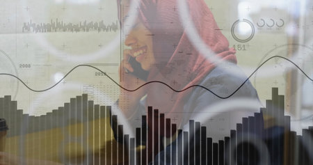 Talking woman wearing red headscarf, blazer analyzing charts at cafe, with coffee cup, smartphone. Professional, business, data, analysis, communication, workspace, modernの写真素材