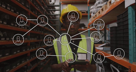 Tapping tablet, worker wearing hard hat and vest checking inventory on shelving with network icons....