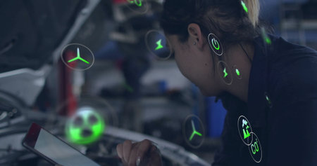 Leaning technician in uniform holding tablet over car hood in garage with AR icons, copy space. Innovative, technical, futuristic, industrial, professional, digital, engineeringの写真素材