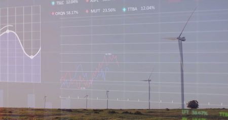 Displaying single large wind turbine standing over grassland with overlaid stock charts, copy space....