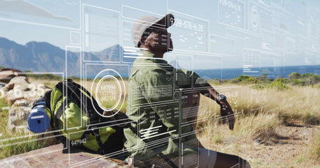 Sitting man wearing wide hat on coastal bench beside backpack and rolled mat, with digital overlays. Adventure, exploration, tranquility, technology, outdoor, scenery, travelの写真素材