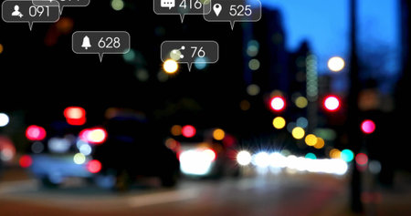 Displaying digital notification icons overlaying night city street, with blurred cars, bokeh lights. Urban, nightlife, technology, digital, illumination, modern, motionの写真素材