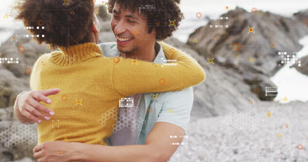 Couple hugging on pebble beach wearing lightblue Tshirt and mustardyellow sweater, with AR overlays. Romance, connection, serenity, nature, tranquility, digital art, affectionの写真素材