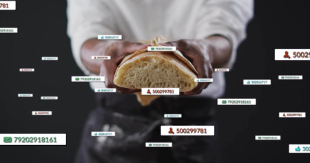Mid-adult chef wearing apron holding halved loaf in studio, with notifications showing like counts. Artisan, culinary, modern, digital, technology, professional, merchandiseの写真素材