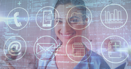 Smiling Indian woman in blue shirt displaying telephone, cloud, chat icons with code in office....