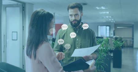 Reviewing documents, office colleagues discussing single sheet and dark folder in open-plan office. Collaboration, teamwork, professionalism, modern, workspace, corporate, productivityの写真素材