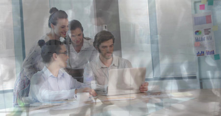 Collaborating professionals wearing business attire examining laptop screen in modern meeting room. Collaboration, teamwork, business, innovation, strategy, brainstorming, modernの写真素材
