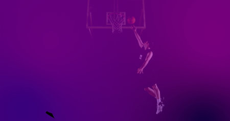 Basketball player dunking basketball in gym, with hoop net, jersey and athletic shoes, copy space. Athletic, action, sport, dynamic, vibrant, intense, high-energyの写真素材