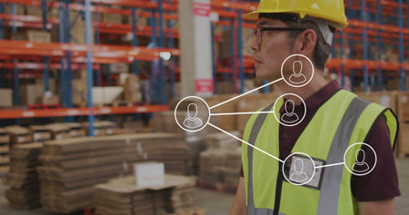 Highlighting network map over Korean worker wearing hard hat in warehouse with racks, copy space....