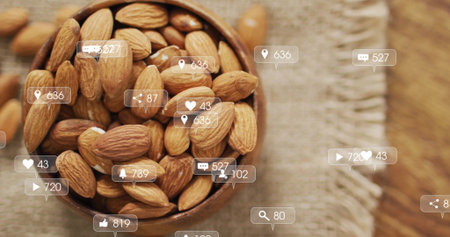 Showing wooden bowl with almonds and loose almonds on woven cloth, with social media icons floating. Nuts, snack, health, natural, organic, rusticの写真素材