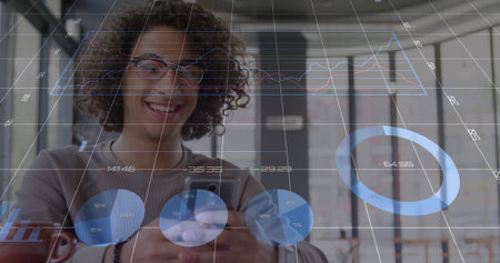 Smiling man looking down at smartphone in coworking space, with data overlays and coffee mug. Technology, analytics, workspace, innovation, modern, collaboration, professionalの写真素材