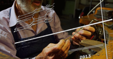 Craftsman holding metal part and filing edges at workbench with vise, wearing striped shirt, apron....