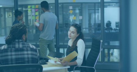 Reviewing documents woman in blouse holding yellow folder in office with sticky notes, copy space. Collaboration, teamwork, brainstorming, innovation, communication, modernity, productivityの写真素材