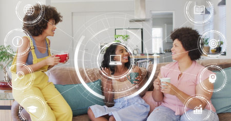 Chatting three friends holding mugs around sofa in bright living room. Coziness, friendship, socializing, relaxation, modern, cozy, vibrantの写真素材