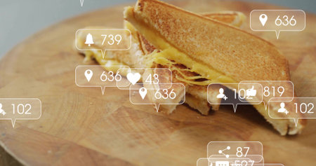 Stacking toasted sandwich halves on cutting board on counter, with social media notification icons....