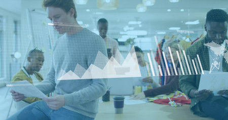 Collaborating six colleagues analyzing digital charts around office table, with laptops and reports. Team, innovation, productivity, brainstorming, modern, professional, technologyの写真素材