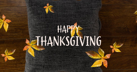 Image of happy thanksgiving text over fall leaves and pillow. Thanksgiving, celebration and digital...