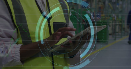 Monitoring production line technician wearing neon safety vest with radio using tablet, copy space....