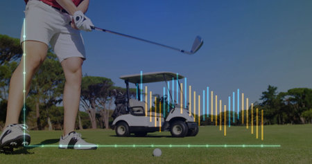 Swinging male golfer striking golf ball on fairway, with iron club, golf cart and analytics overlay. Athletic, leisure, modern, outdoor, activity, vibrant, sportの写真素材