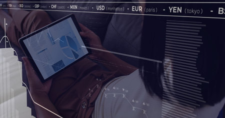 Holding tablet, Asian executive analyzing pie chart and bar graph in lounge area, currency ticker. Tech, analytics, financial, digital, corporate, marketing, professionalの写真素材