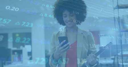 Smiling businesswoman checking smartphone, holding clipboard in open plan office, with data overlay. Professional, corporate, modern, technology, finance, productivity, communicationの写真素材