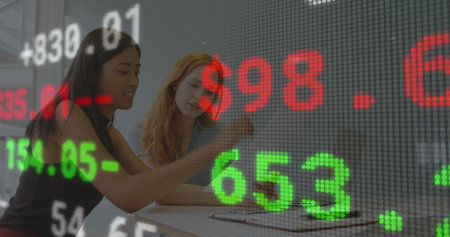 Collaborating two colleagues analyzing financial data at boardroom, with tablet and stock overlay. Business, teamwork, technology, data, analytics, modern, professionalの写真素材