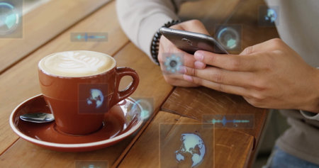 Man wearing tan sweater gripping phone at cafe table, with latte cup, floating icons, copy space....
